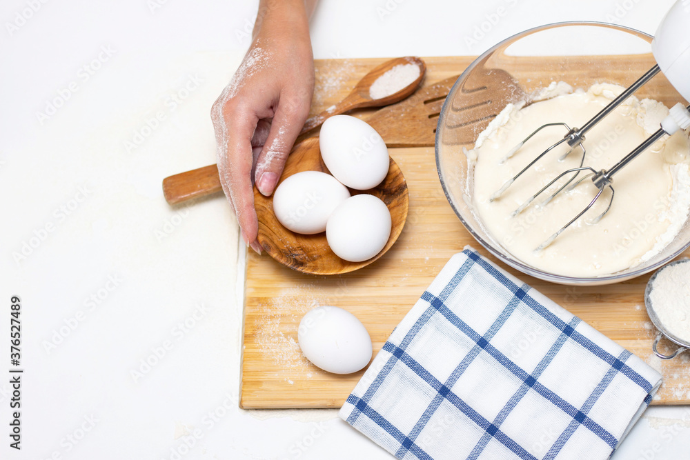 making dough for bread or homemade baked goods. ingredients on the desk. female hands hold a mixer for mixing dough making dough for bread or homemade baked goods. ingredients on the desk. female hands hold a mixer for mixing dough