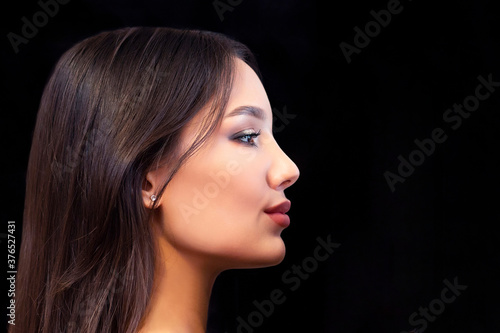 Close up portrait in profile of young beautiful woman with smoky eye makeup