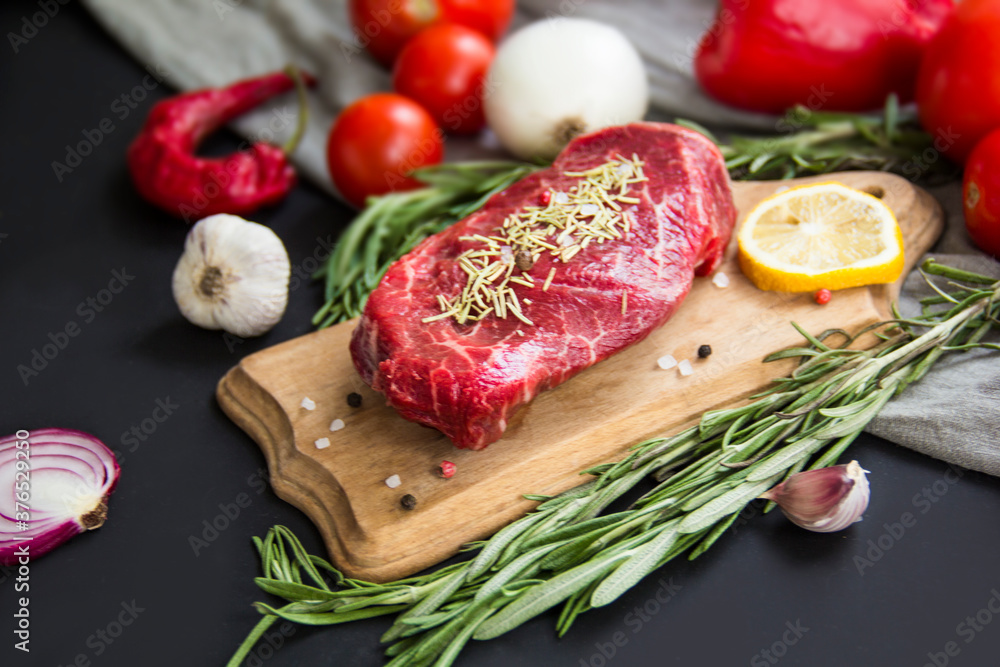 Raw beef steak on a cutting board with spices. Creative atmospheric decoration. Raw beef steak on a cutting board with spices. Creative atmospheric decoration.