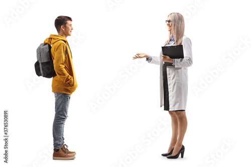Full length profile shot of a female doctor talking to a male teenage student
