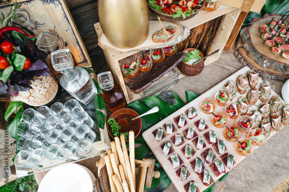 Top view of delicious appetizers on luxury wedding snack bar. Table catering with canapes and salads. Preparing for eating on birthday celebration. Concept of beautiful unhealthy nutrition, carories. Top view of delicious appetizers on luxury wedding snack bar. Table catering with canapes and salads. Preparing for eating on birthday celebration. Concept of beautiful unhealthy nutrition, carories.