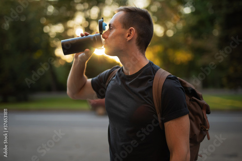 Man drink watter from thermos
