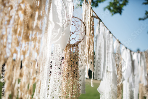 Fotografía Close up of hanging beige, white ribbon, dream catcher on backyard, beautiful sunny day
