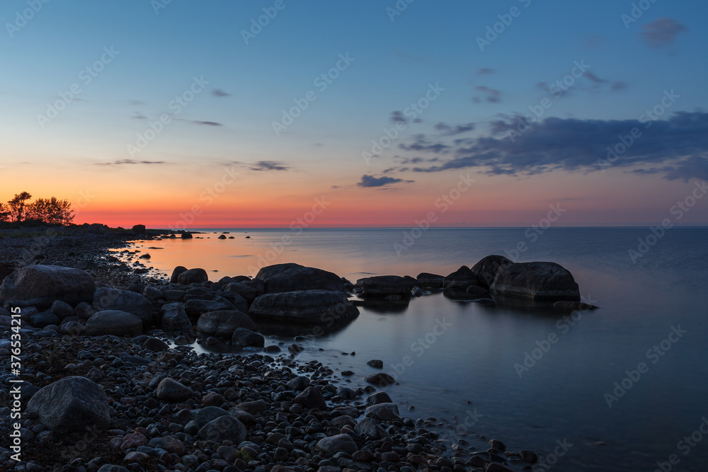 Obraz premium Rocky shore and peninsula of Baltic sea at sunset. Nordic minimalistic wilderness.