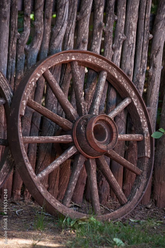 Old Wagon Wheel against a fence
