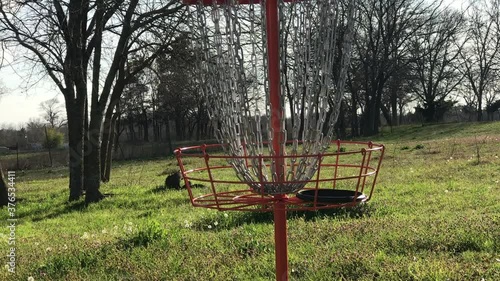 Disc golf flying and landing in basket photo
