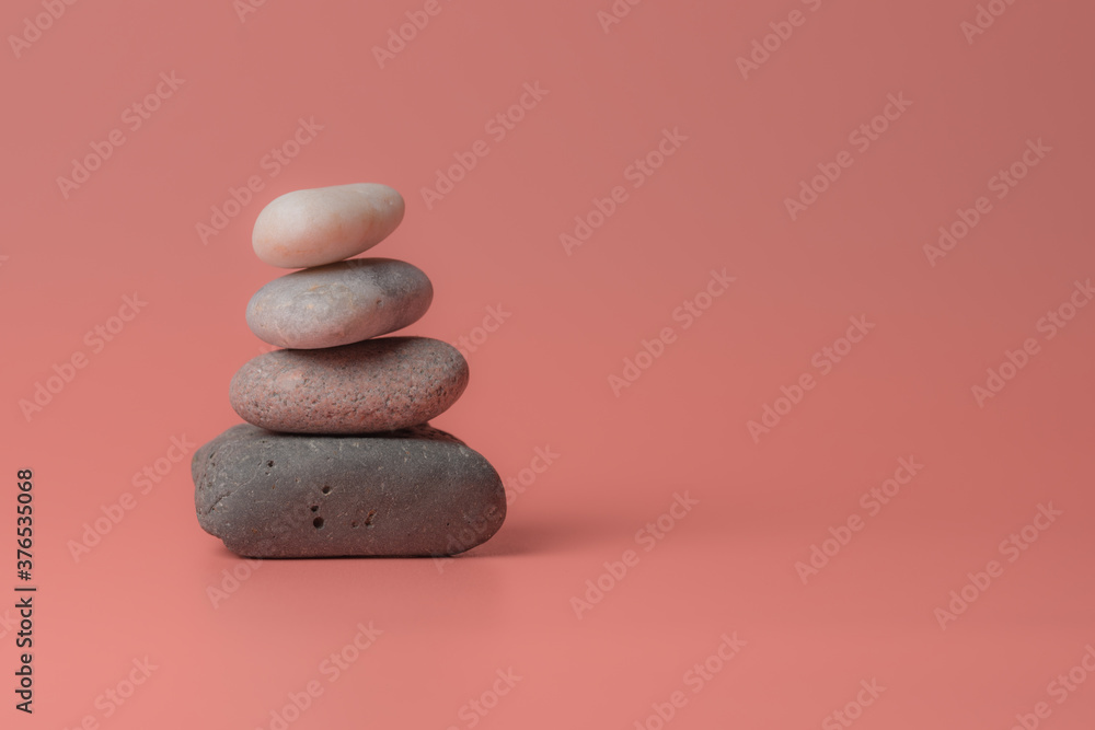 Stack of Zen pebbles on a pink background Stack of Zen pebbles on a pink background