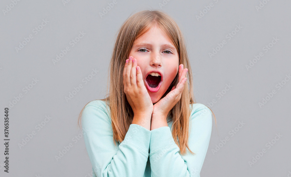 Surprised happy beautiful woman looking sideways in excitement. Isolated on gray background Surprised happy beautiful woman looking sideways in excitement. Isolated on gray background