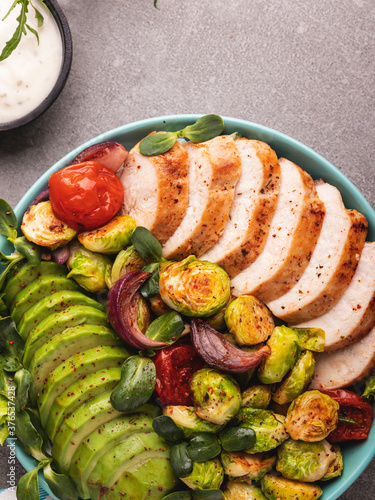 roasted sliced turkey, chicken, fillet with brussels sprouts, avocado, herbs, healthy food photo