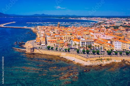 Aerial view over Alghero old town, cityscape Alghero view on a beautiful day with harbor and open sea in view. Alghero, Italy. Panoramic aerial view of Alghero, Sardinia, Italy. photo