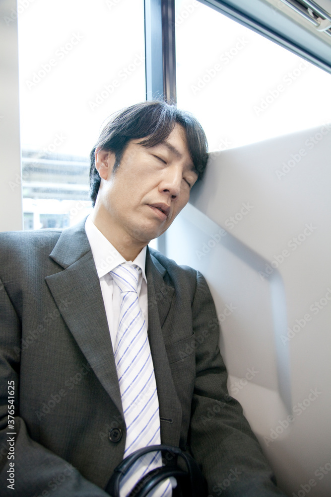 電車で居眠りするビジネスマン 電車で居眠りするビジネスマン
