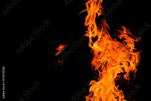Bright orange red Fire flame against black background with copyspace, abstract texture
