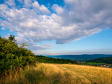Mountainous landscape with clouds in the blue sky and the Ore Mountains on the horizon