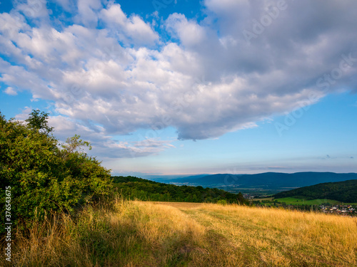 Mountainous landscape with clouds in the blue sky and the Ore Mountains on the horizon