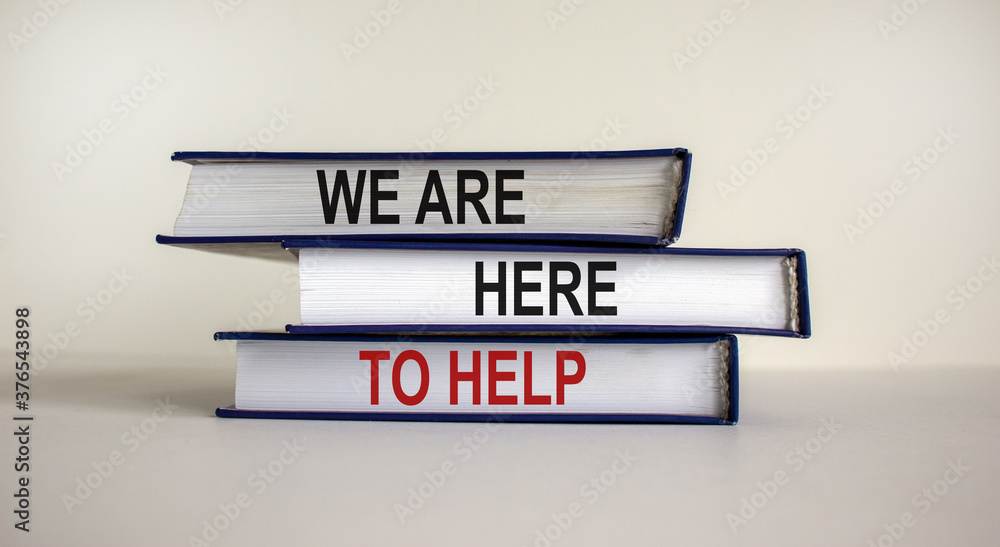 Books with text 'we are here to help' on beautiful white table. White background. Business concept. Copy space.