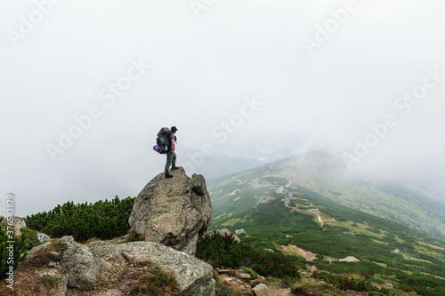 Hikers with backpacks enjoying valley view from top of a mountain