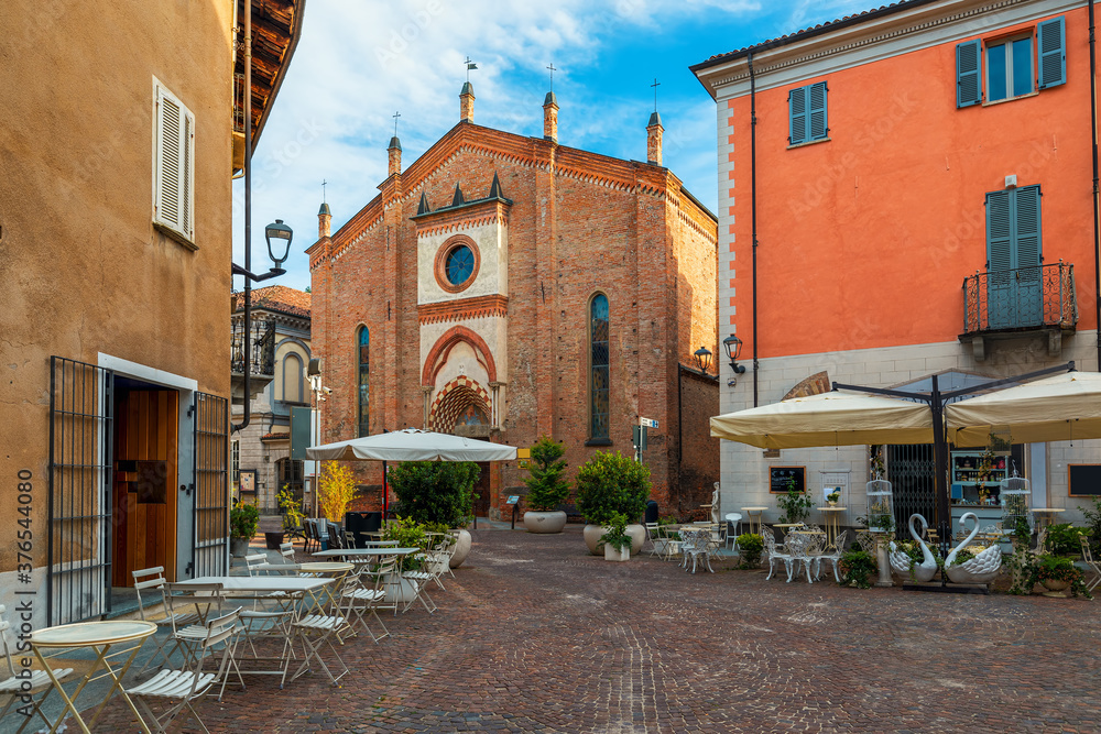 Cobblestone street and San Domenico church in Alba, Italy.