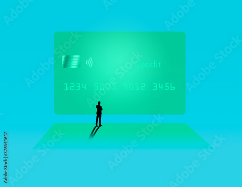 A silhouetted man stands in front of a huge image of a generic credit card on a movie screeen in this illustration.
