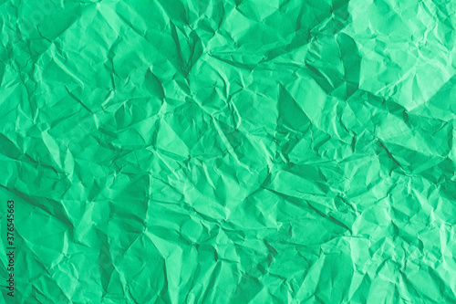Green paper is wrinkled in the background.