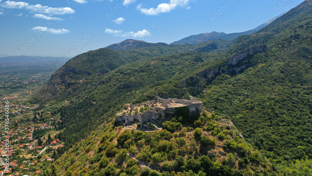 Aerial drone photo of iconic medieval byzantine uphill castle of Mystras with great scenic view to town of Mystras and Monasteries, Sparta, Peloponnese, Greece