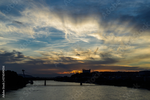 Canvas Print Sunset over Danube river with silhouettes of castle and SNP bridge, known landma