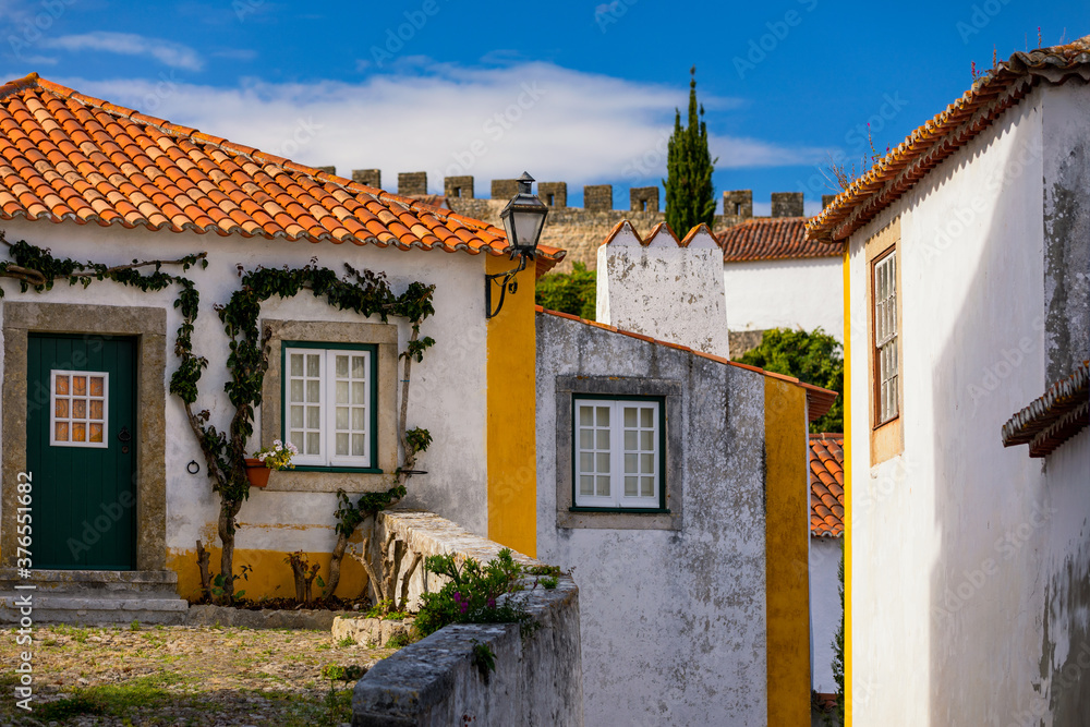 Historic walled town of Obidos, near Lisbon, Portugal. Beautiful streets of Obidos Medieval Town, Portugal. Street view of medieval fortress in Obidos. Portugal.