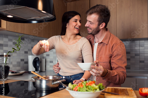 Couple enjoying preparing dinner in kitchen 