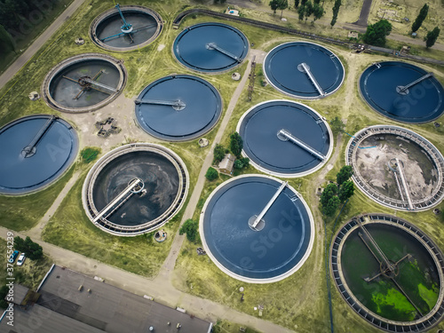 Water recycling and filtration in sewage treatment station in round tanks, aerial view.