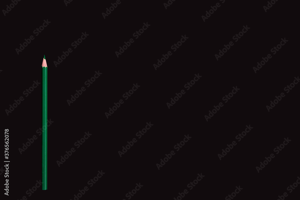 Green pencil on dark background, side border from top view. Empty space for text. Green pencil on dark background, side border from top view. Empty space for text.