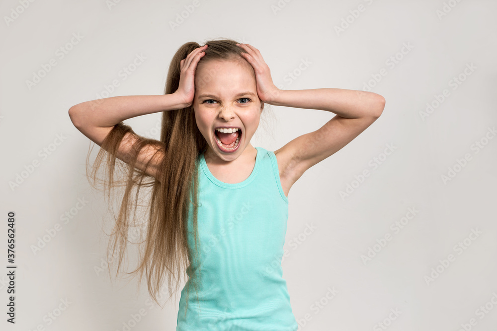 little girl is screaming and holding her head by hands. little girl is screaming and holding her head by hands.