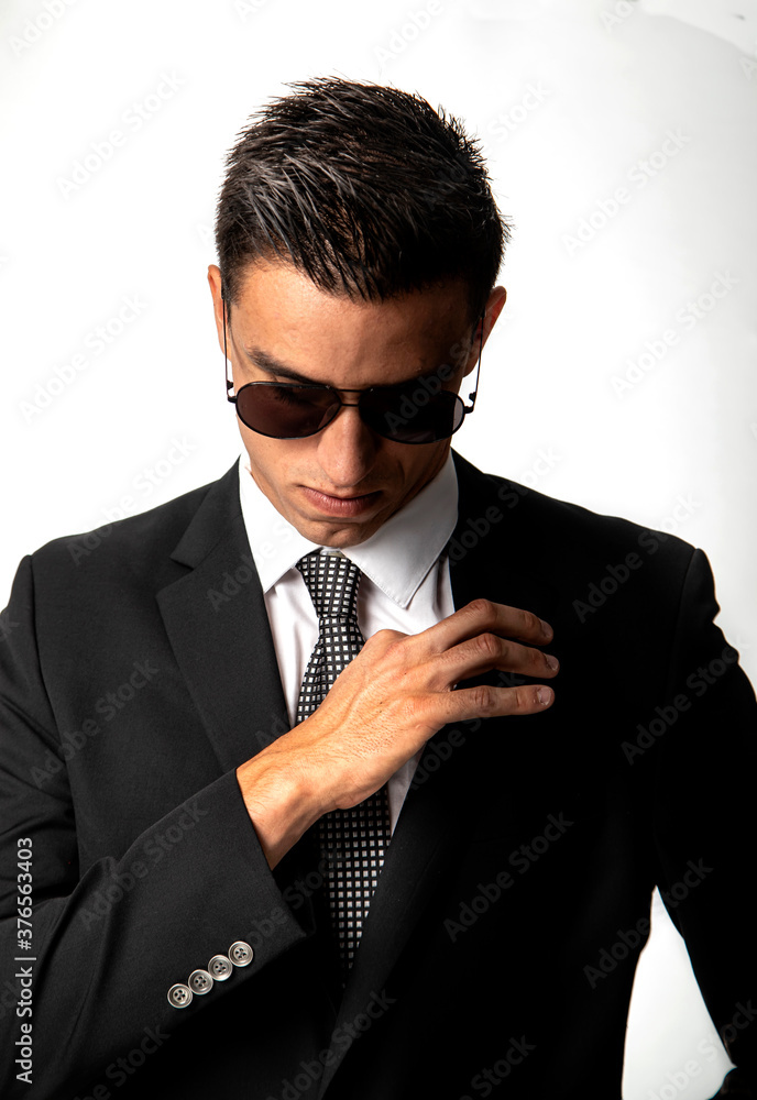 Poster Print Attractive young man in business suit and sunglasses looking straight down on wh 26.7x40 cm