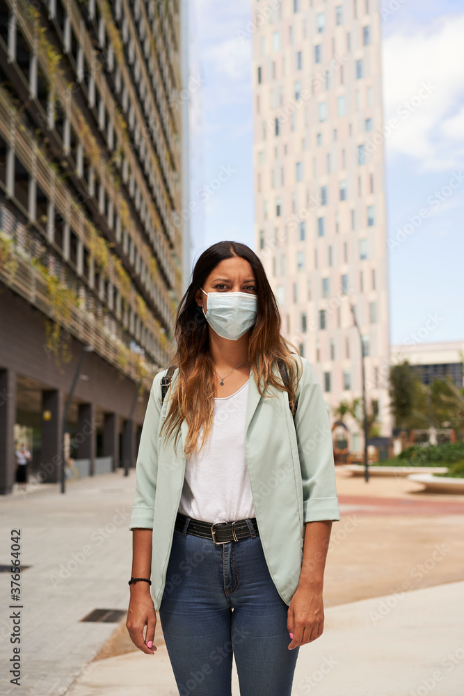 Vertical picture of a working woman wearing mask for the coronavirus pandemic.