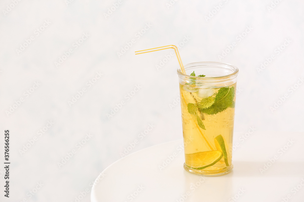 Fototapeta premium Glass of tasty cold ice tea on table against white background