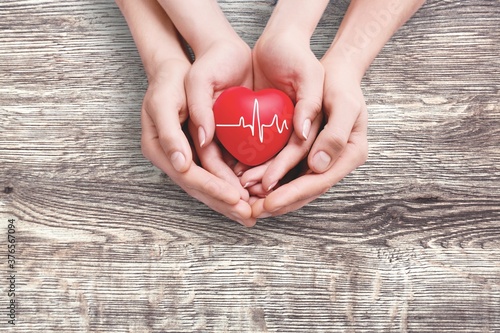 Man and woman hands holding the red heart