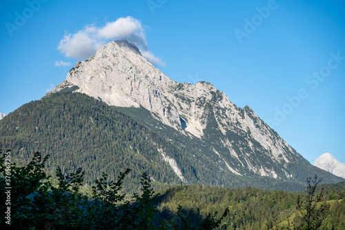 peaks of the wetterstein mountains in the clouds in the early morning, view from mittenwald town photo