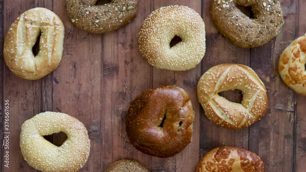 Grabbing a Bagel from a Wooden Table Grabbing a Bagel from a Wooden Table