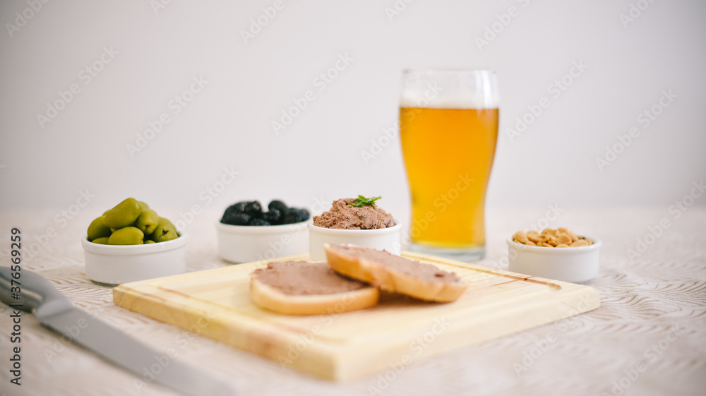 Tostadas con leberwurst acompañado por aceitunas, maní y cerveza Tostadas con leberwurst acompañado por aceitunas, maní y cerveza