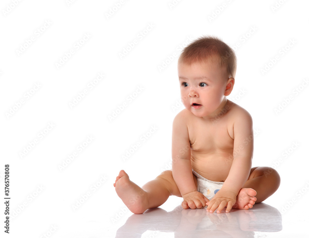 Little baby in nappy on floor stretching out by hand Little baby in nappy on floor stretching out by hand