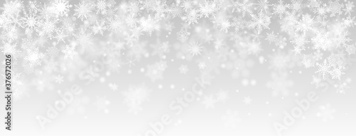 Christmas background of falling snowflakes in gray colors