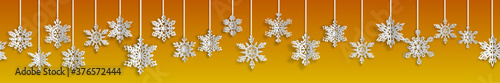 Christmas seamless banner with volume paper snowflakes with soft shadows on yellow background. With horizontal repetition