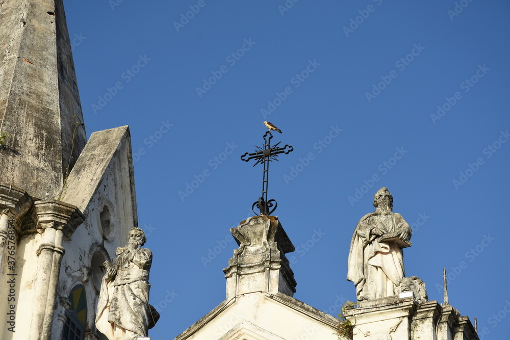bird on top of cross in historic church in the city of São Luís, Brazil