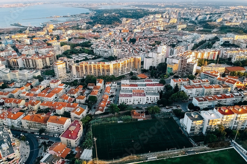 View of the city from above, the statue of Christ on the banks of the Tagus River, narrow streets and roofs of houses with red tiles Lisbon.