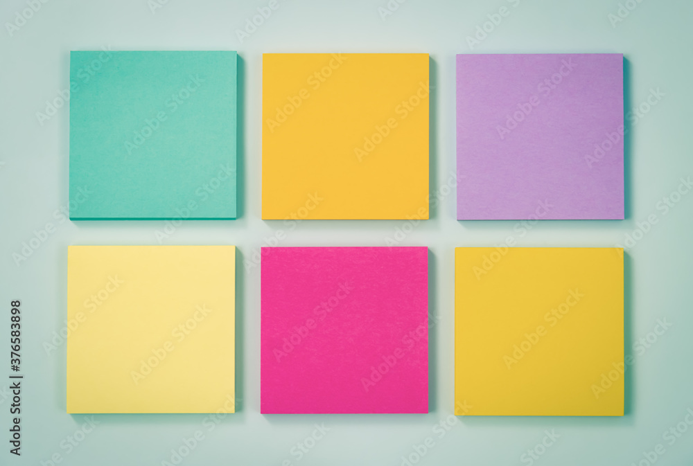 6 Color Stick Note or Note Pad as Green,Purple,Pink,Yellow on Modern Clean Creative Office Desk or Office Table on Top View. Office Supplies on Blue Pastel Minimalist Background in Vintage Tone