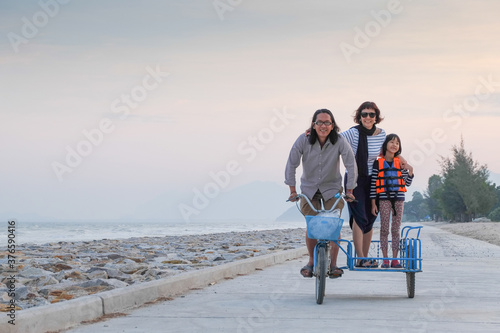 Asian families enjoy local tricycles on the beach on a nice day.