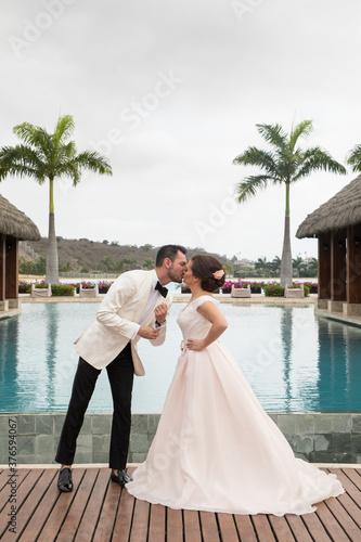 Latino Bride and groom with white tuxedo 