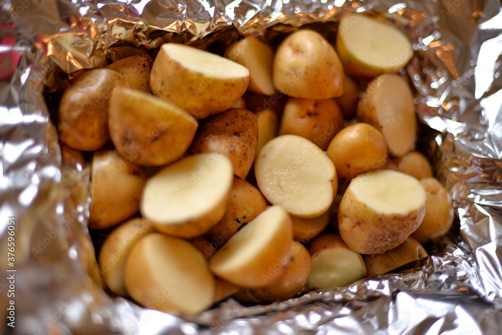 the process of cooking potatoes wrapped in foil, on the grill at home, with your own hands, on an autumn day the process of cooking potatoes wrapped in foil, on the grill at home, with your own hands, on an autumn day