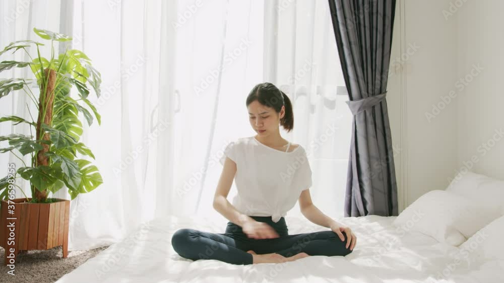 Asian woman sitting on the bedroom and yoga exercising pose in the morning after waking up. Asian woman sitting on the bedroom and yoga exercising pose in the morning after waking up.