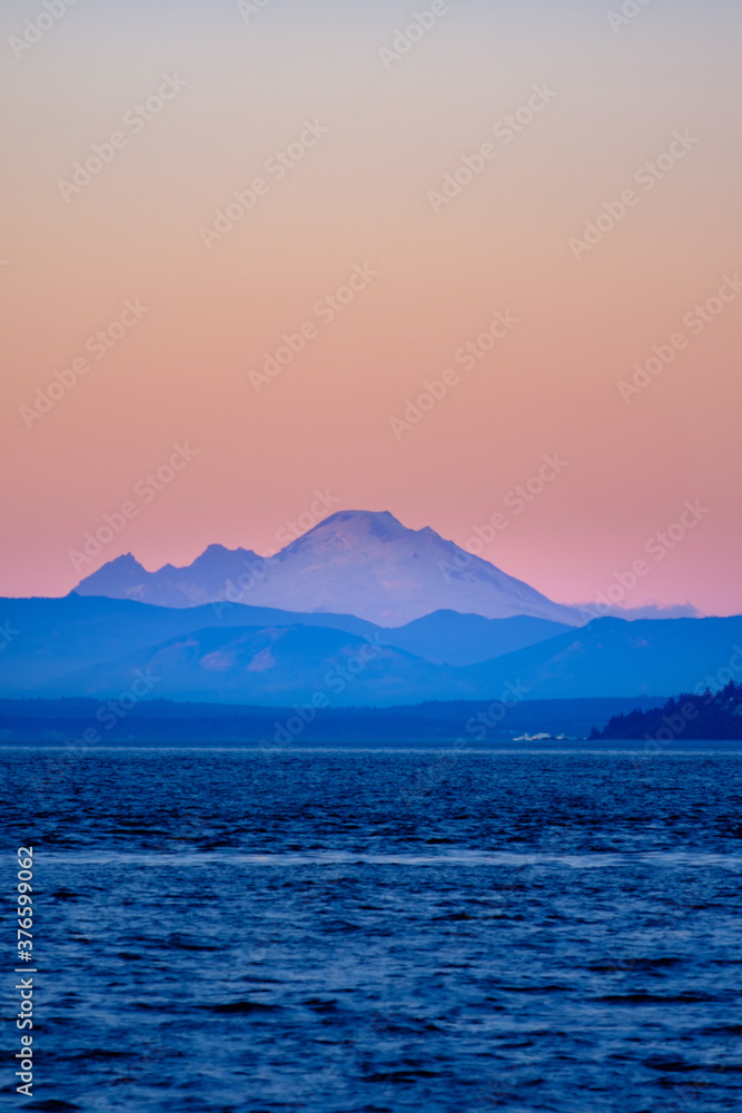Mt. Baker glows in the colors of dusk over the ocean and Puget Sound