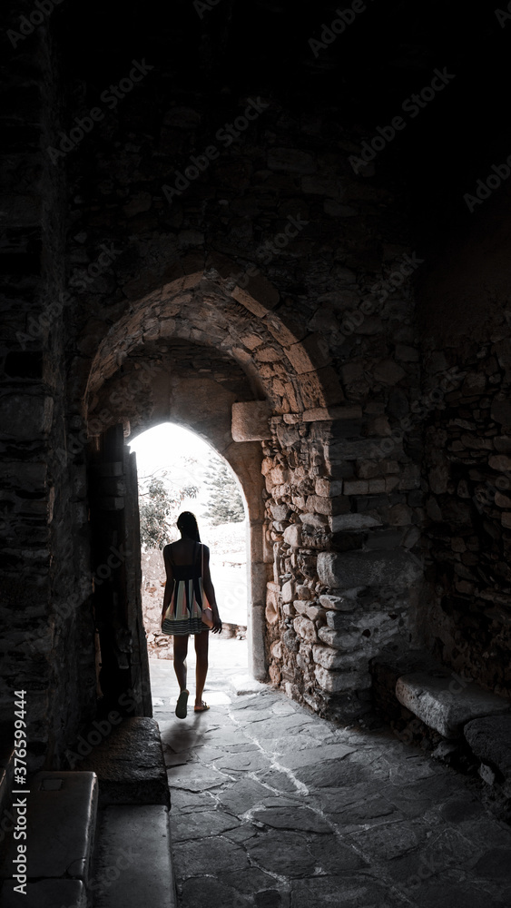 Dark-skinned young attractive woman in backlight at the exit in the arch Dark-skinned young attractive woman in backlight at the exit in the arch