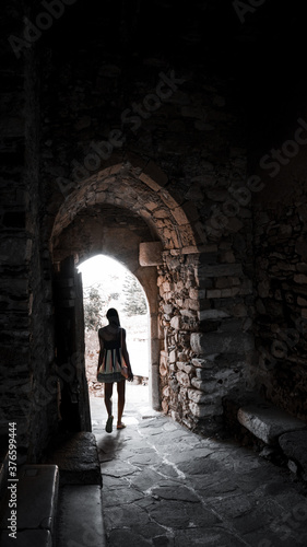  Dark-skinned young attractive woman in backlight at the exit in the arch